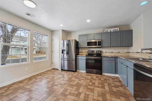 kitchen with recessed lighting, stainless steel appliances, a sink, visible vents, and baseboards