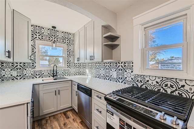 kitchen featuring sink, gray cabinetry, backsplash, stainless steel appliances, and decorative light fixtures