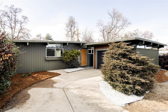 mid-century modern home with an attached garage and concrete driveway