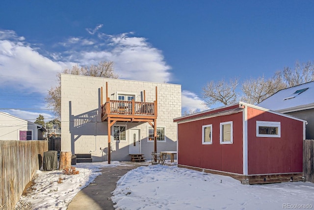 view of snow covered back of property