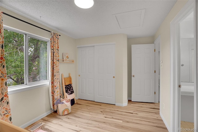 2140 W 135th Ave, Westminster, CO 80234 - bedroom featuring light wood-style flooring, baseboards, attic access, a closet, and a textured ceiling
