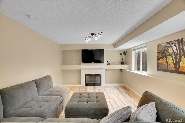 2140 W 135th Ave, Westminster, CO 80234 - living area with wood finished floors, a textured ceiling, a fireplace, rail lighting, and baseboards