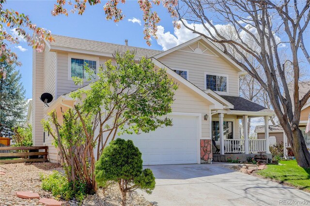 traditional home with a garage, fence, covered porch, a shingled roof, and driveway