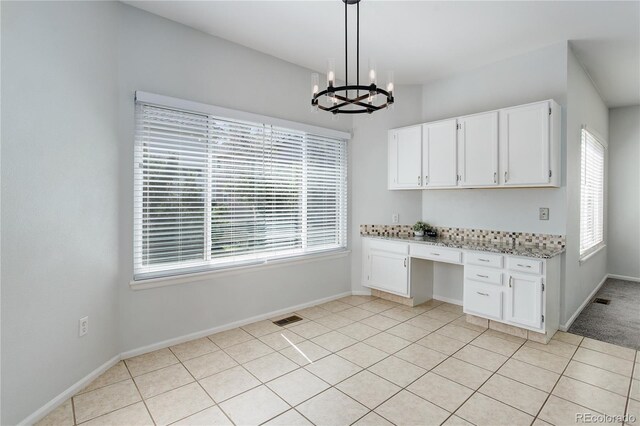 kitchen with an inviting chandelier, built in desk, plenty of natural light, and visible vents