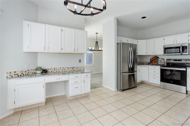 kitchen featuring an inviting chandelier, built in study area, white cabinets, light stone counters, and stainless steel appliances
