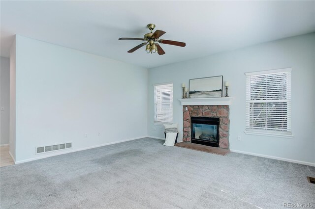 unfurnished living room with a wealth of natural light, carpet flooring, and visible vents