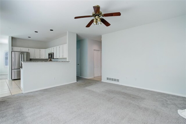 unfurnished living room with visible vents, a ceiling fan, baseboards, and light carpet