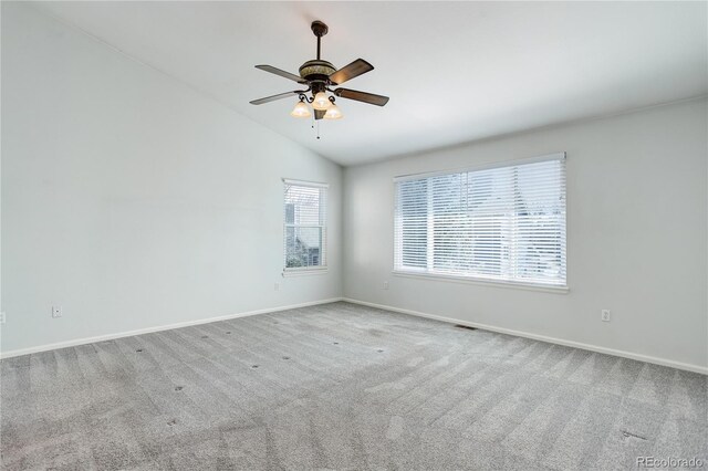 carpeted spare room with baseboards, vaulted ceiling, and ceiling fan