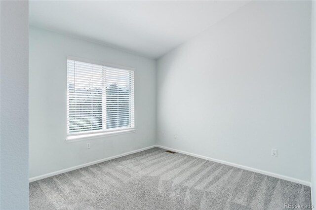 carpeted spare room with baseboards and visible vents