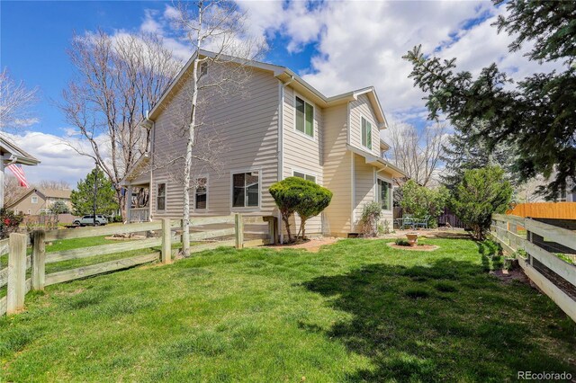 view of side of property with a lawn and a fenced backyard