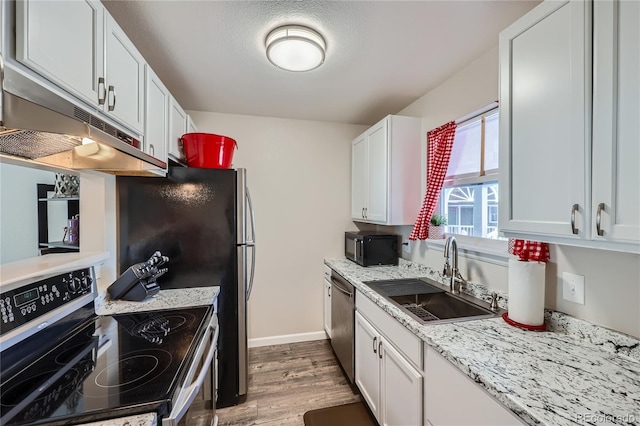 kitchen with appliances with stainless steel finishes, wood-type flooring, white cabinetry, sink, and light stone counters