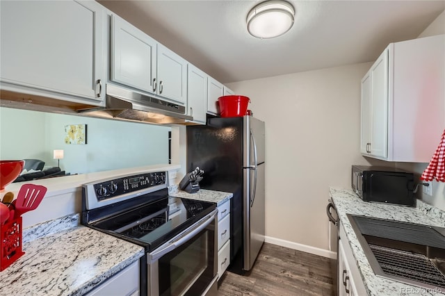 kitchen featuring light stone countertops, white cabinets, appliances with stainless steel finishes, and dark hardwood / wood-style floors