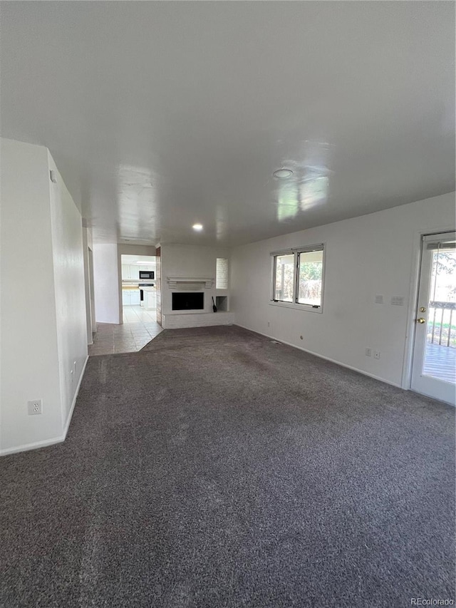 15983 E Loyola Dr, Aurora, CO 80013 - unfurnished living room featuring carpet flooring, baseboards, and a fireplace