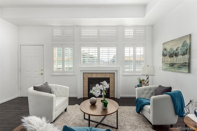 living room with a healthy amount of sunlight, a fireplace, and dark wood-type flooring