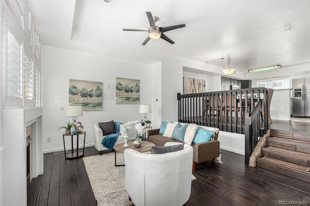 living room featuring ceiling fan and dark hardwood / wood-style flooring