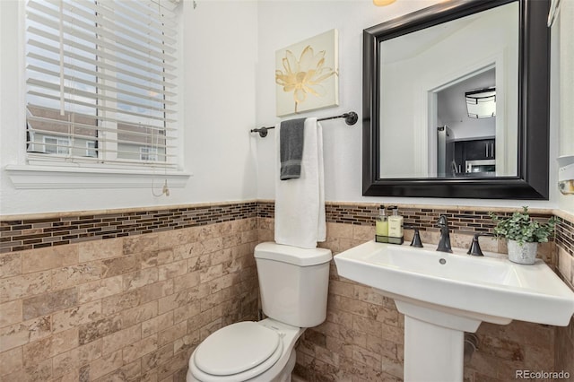 bathroom with tile walls and toilet