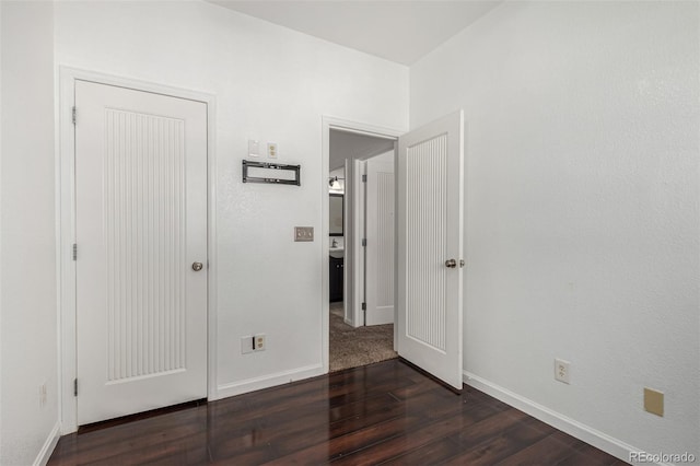 unfurnished bedroom with dark wood-type flooring