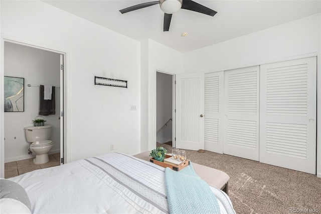 carpeted bedroom with ensuite bath and ceiling fan