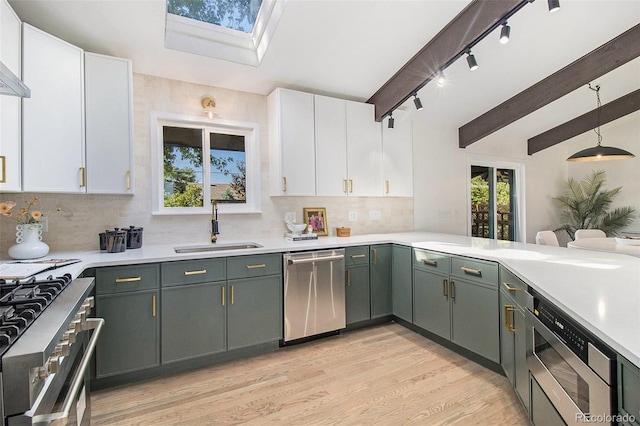 14890 W 58th Pl, Golden, CO 80403 - kitchen featuring stainless steel appliances, a skylight, light countertops, white cabinets, and backsplash