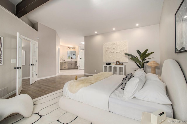 14890 W 58th Pl, Golden, CO 80403 - bedroom with wood finished floors, recessed lighting, ensuite bath, and beamed ceiling