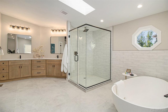 14890 W 58th Pl, Golden, CO 80403 - bathroom with double vanity, a soaking tub, a stall shower, a skylight, and recessed lighting