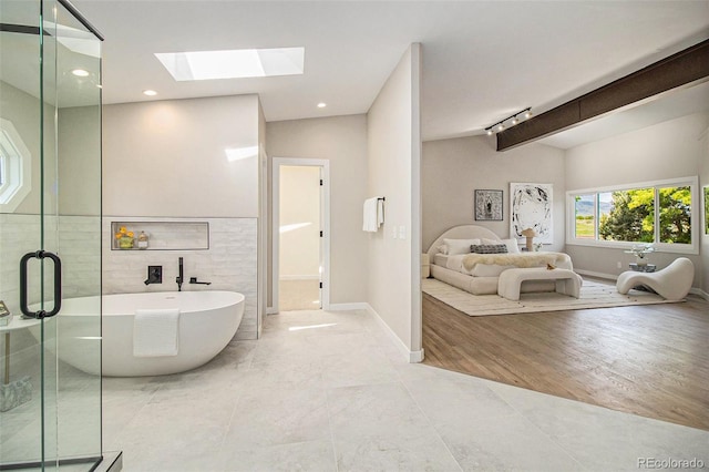 14890 W 58th Pl, Golden, CO 80403 - bathroom featuring a skylight, a freestanding tub, a stall shower, track lighting, and recessed lighting