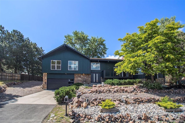 14890 W 58th Pl, Golden, CO 80403 - view of front of home with stone siding, an attached garage, and concrete driveway