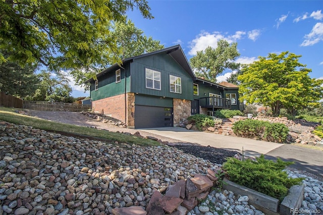 14890 W 58th Pl, Golden, CO 80403 - view of property exterior with an attached garage, driveway, and stone siding