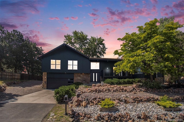 14890 W 58th Pl, Golden, CO 80403 - view of front facade featuring an attached garage, stone siding, and driveway