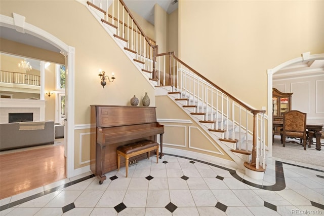 interior space with light tile patterned flooring, a towering ceiling, and an inviting chandelier