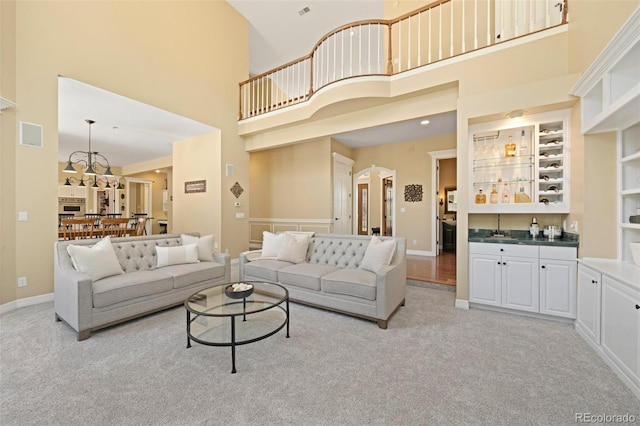 carpeted living room with a high ceiling and indoor wet bar