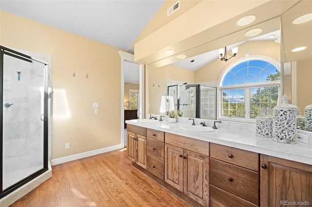 bathroom with hardwood / wood-style flooring, vanity, lofted ceiling, and a shower with shower door