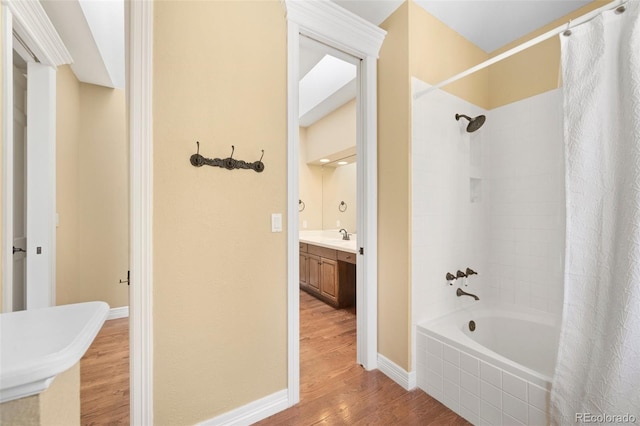 bathroom featuring hardwood / wood-style flooring, vanity, and shower / bath combo with shower curtain