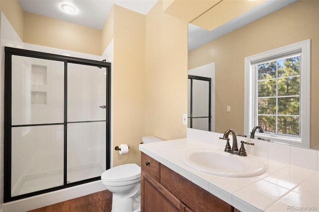 bathroom featuring vanity, toilet, a shower with shower door, and hardwood / wood-style floors