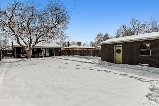 yard covered in snow featuring fence