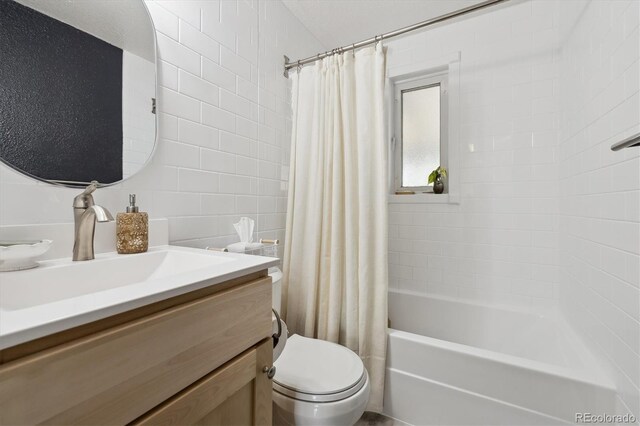 bathroom featuring shower / bath combo with shower curtain, toilet, tile walls, and vanity