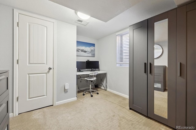 office area with visible vents, baseboards, light colored carpet, and a textured ceiling