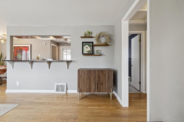 living area featuring light wood-type flooring, baseboards, and a ceiling fan