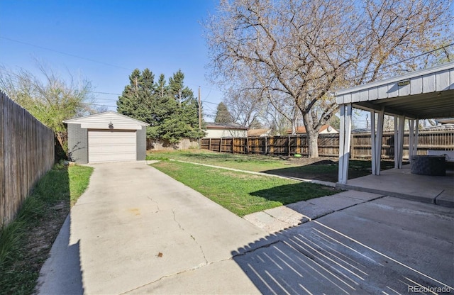 view of yard featuring an outbuilding, a garage, concrete driveway, and a patio