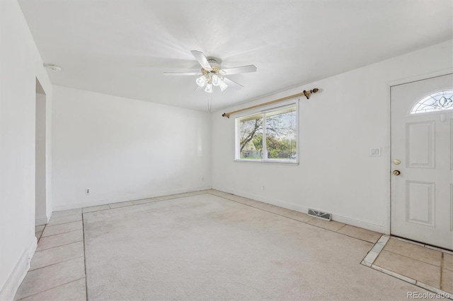 foyer entrance with healthy amount of natural light, ceiling fan, and baseboards