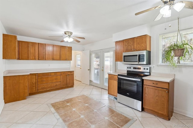 kitchen featuring stainless steel appliances, ceiling fan, brown cabinets, and healthy amount of natural light