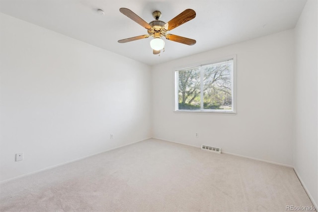 spare room with carpet floors, a ceiling fan, and baseboards
