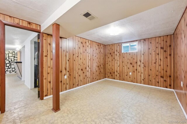 below grade area with tile patterned floors and wood walls