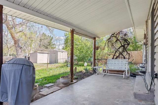 view of patio / terrace featuring a storage shed, grilling area, an outdoor structure, and fence