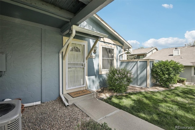 12115 Bannock St Unit B, Denver, CO 80234 - doorway to property featuring cooling unit, a lawn, and stucco siding