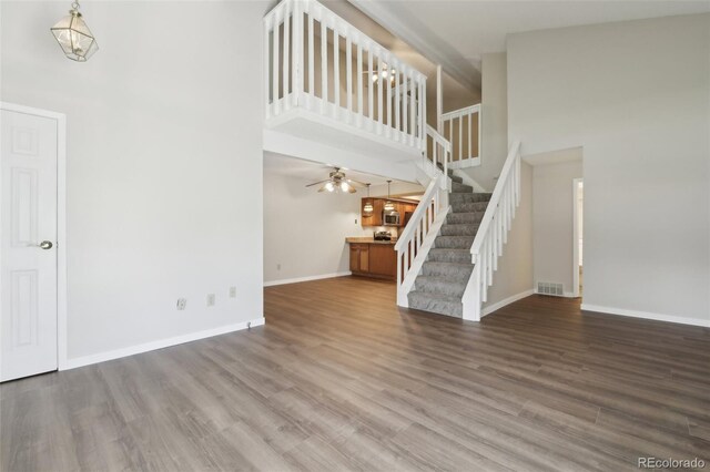 12115 Bannock St Unit B, Denver, CO 80234 - unfurnished living room featuring a high ceiling, stairs, baseboards, wood finished floors, and ceiling fan