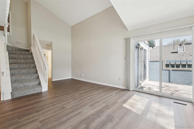 12115 Bannock St Unit B, Denver, CO 80234 - unfurnished living room with wood finished floors, high vaulted ceiling, stairway, and baseboards