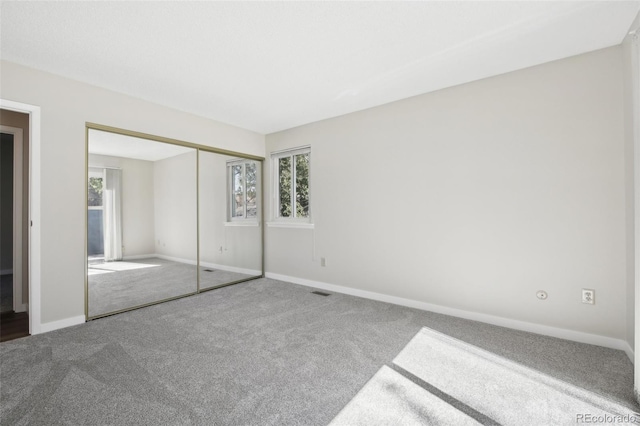 12115 Bannock St Unit B, Denver, CO 80234 - unfurnished bedroom with carpet, multiple windows, baseboards, and a closet