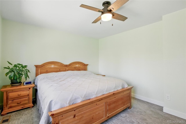 bedroom featuring light colored carpet, a ceiling fan, and baseboards