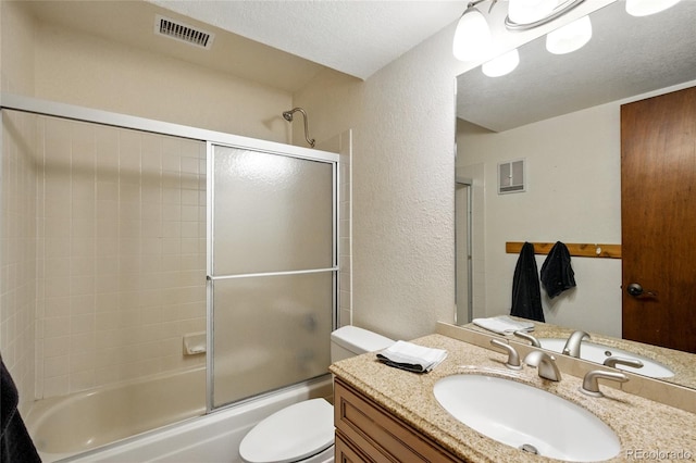 bathroom with toilet, a textured wall, visible vents, and shower / bath combination with glass door